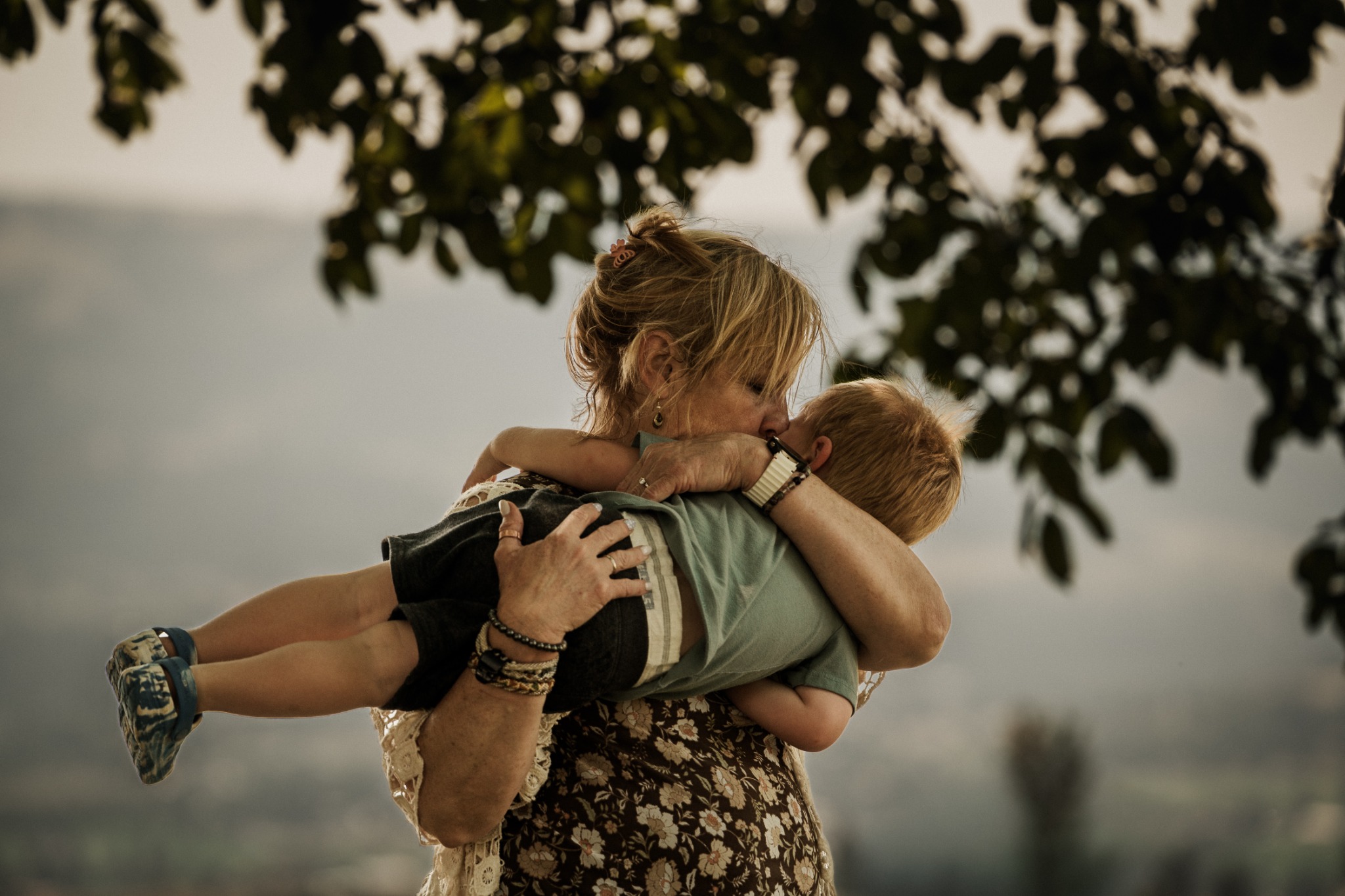 A woman holding and kissing a child