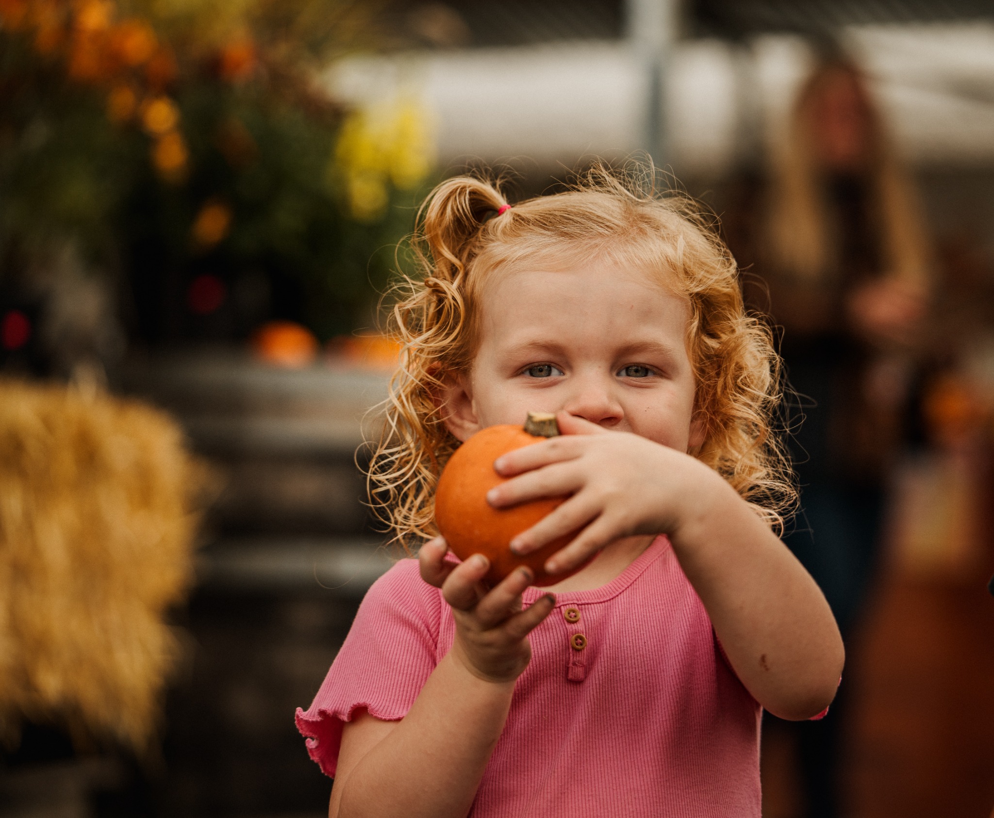 A child holding a small pumpkin