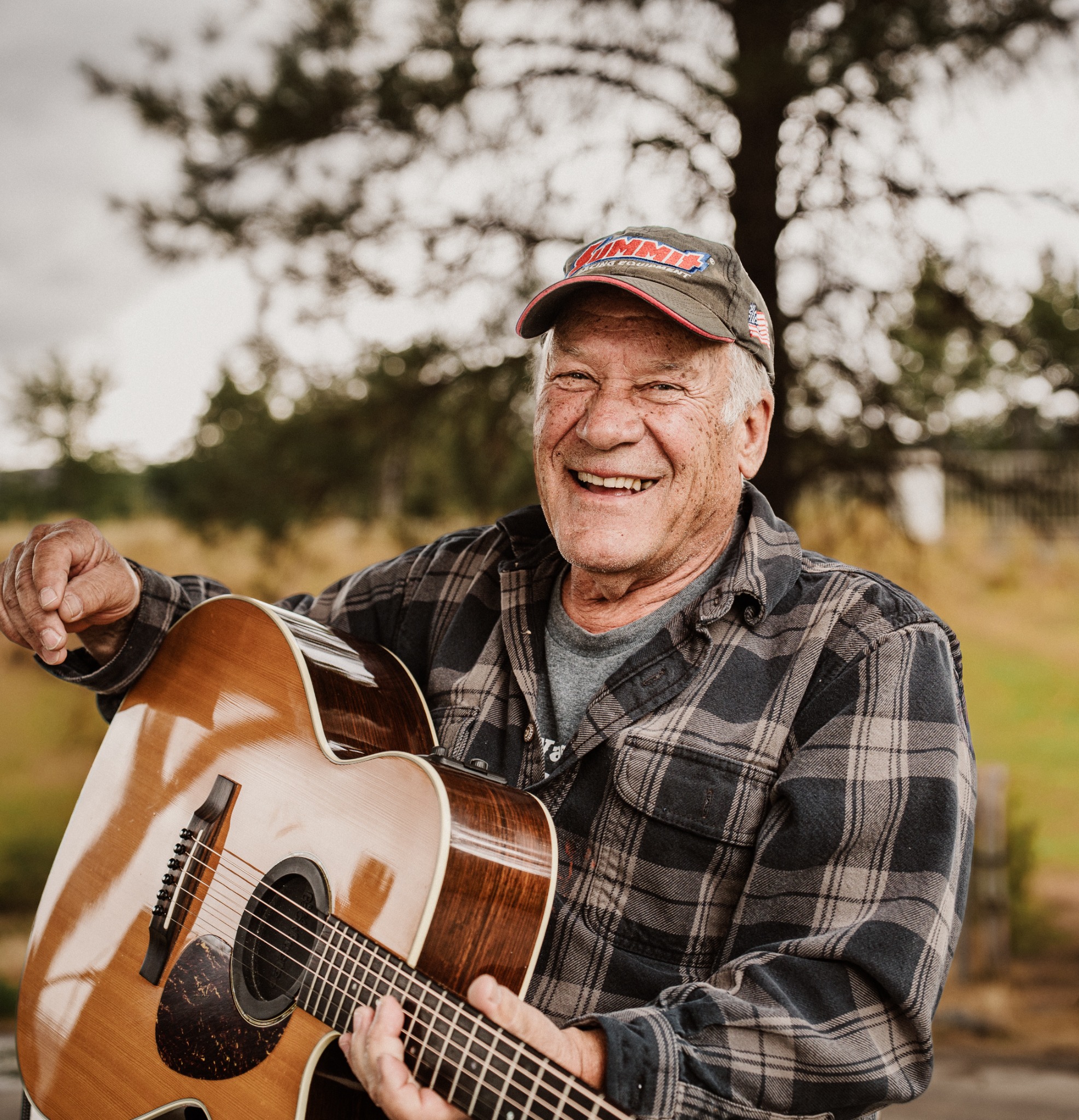 A guitarist laughing outdoors